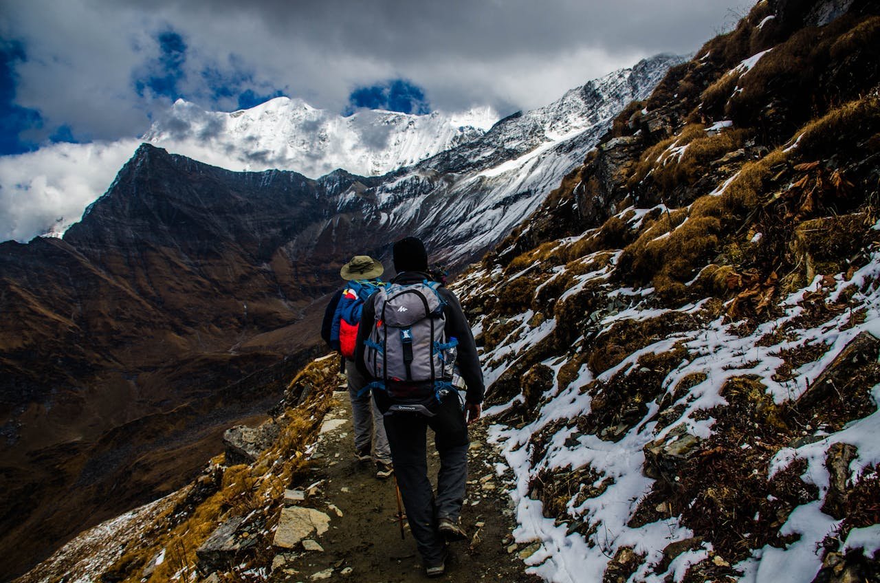 Crafting Captivating Headlines: Your awesome post title goes here Two hikers navigating a snowy trail in rugged mountainous terrain under dramatic skies.